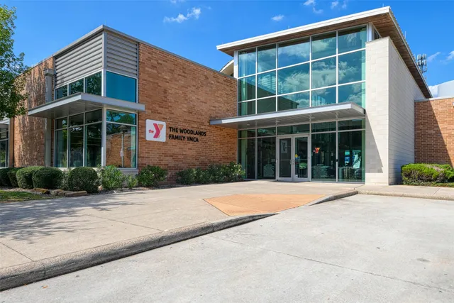 a front view of a building with a yard and potted plants