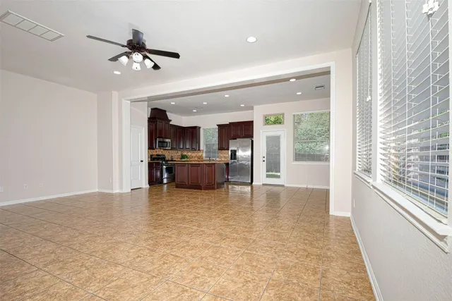 a view of a living room and kitchen with furniture a ceiling fan
