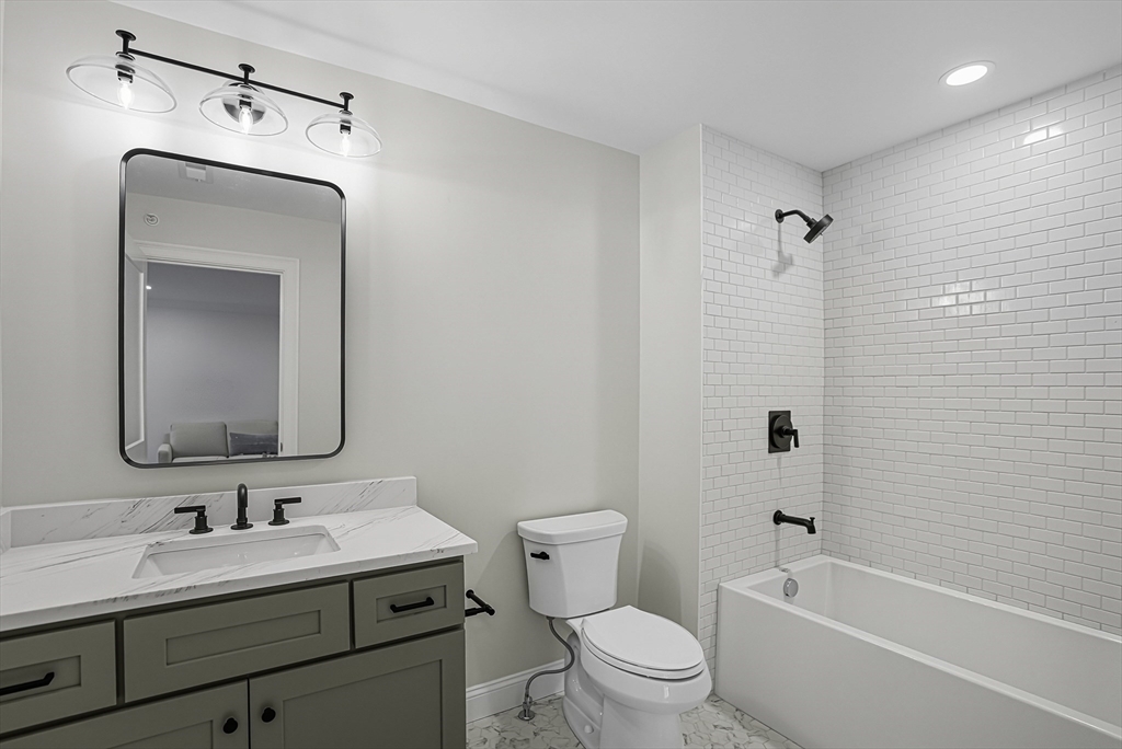 7 Waterville Lane, Unit 7 Hopkinton, MA 01748 - Photo 18 of 31 a bathroom with a toilet a sink a tub and mirror