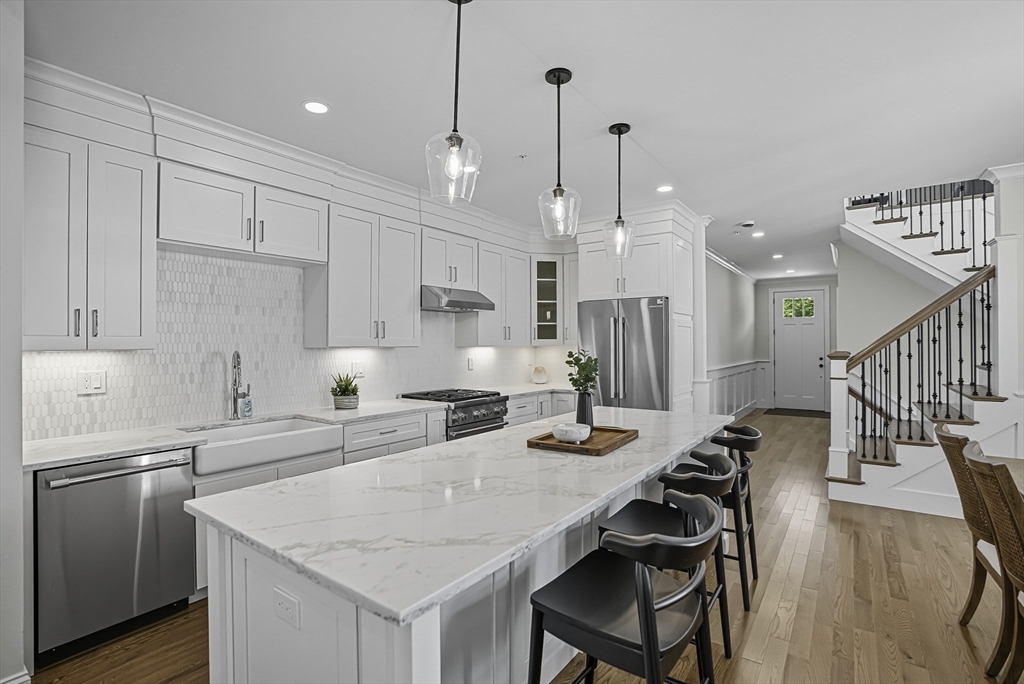 7 Waterville Lane, Unit 7 Hopkinton, MA 01748 - Photo 2 of 31 a kitchen with stainless steel appliances kitchen island a table chairs and a refrigerator