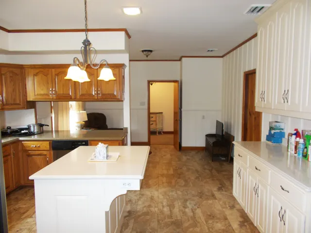 a living room with stainless steel appliances kitchen island granite countertop furniture and a flat screen tv