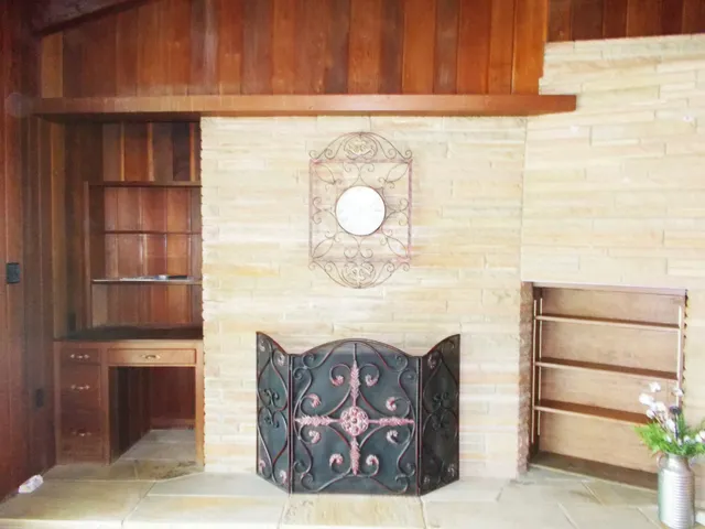 a living room with furniture a fireplace and a large window