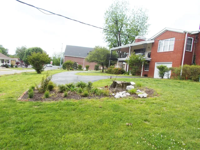 a front view of a house with a yard and lake view