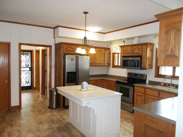 a kitchen with stainless steel appliances granite countertop a sink and a refrigerator