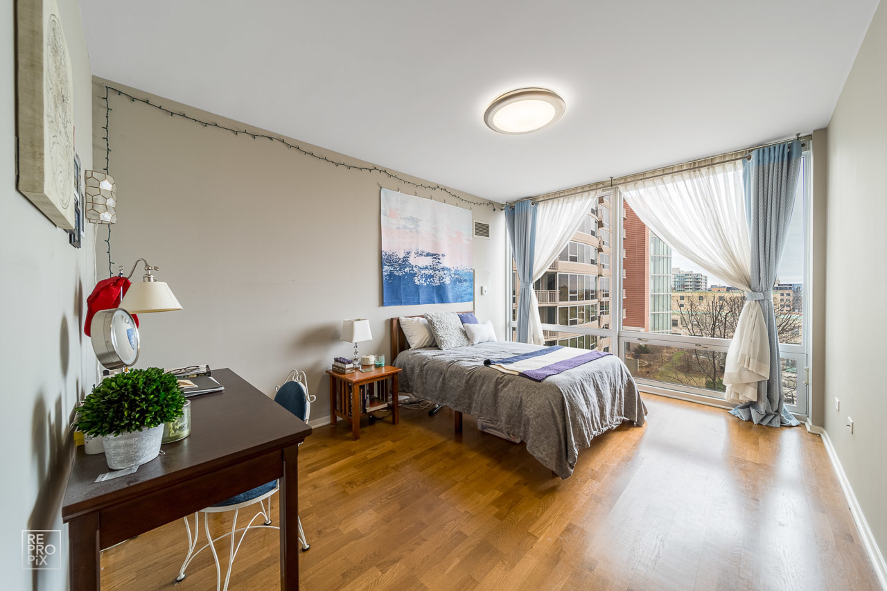 807 Davis Street, Unit 1007 Evanston, IL 60201 - Photo 11 of 14 a bedroom with a bed window and potted plant on the table