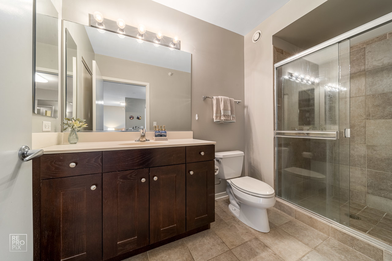 807 Davis Street, Unit 1007 Evanston, IL 60201 - Photo 13 of 14 a bathroom with a sink vanity mirror and toilet