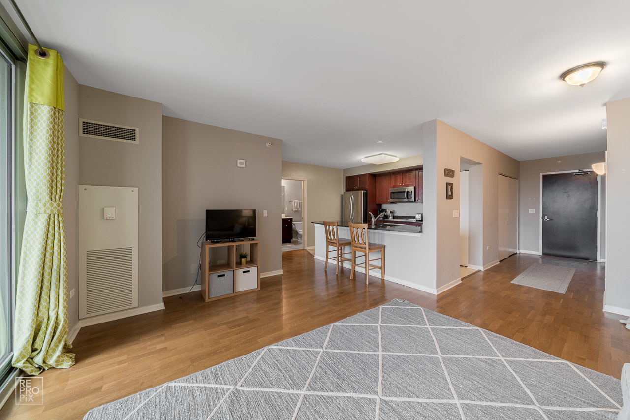 807 Davis Street, Unit 1007 Evanston, IL 60201 - Photo 4 of 14 a room with stainless steel appliances a couch and a view of kitchen living room