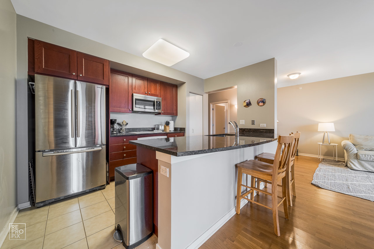 807 Davis Street, Unit 1007 Evanston, IL 60201 - Photo 9 of 14 a kitchen with stainless steel appliances granite countertop a refrigerator and a stove top oven