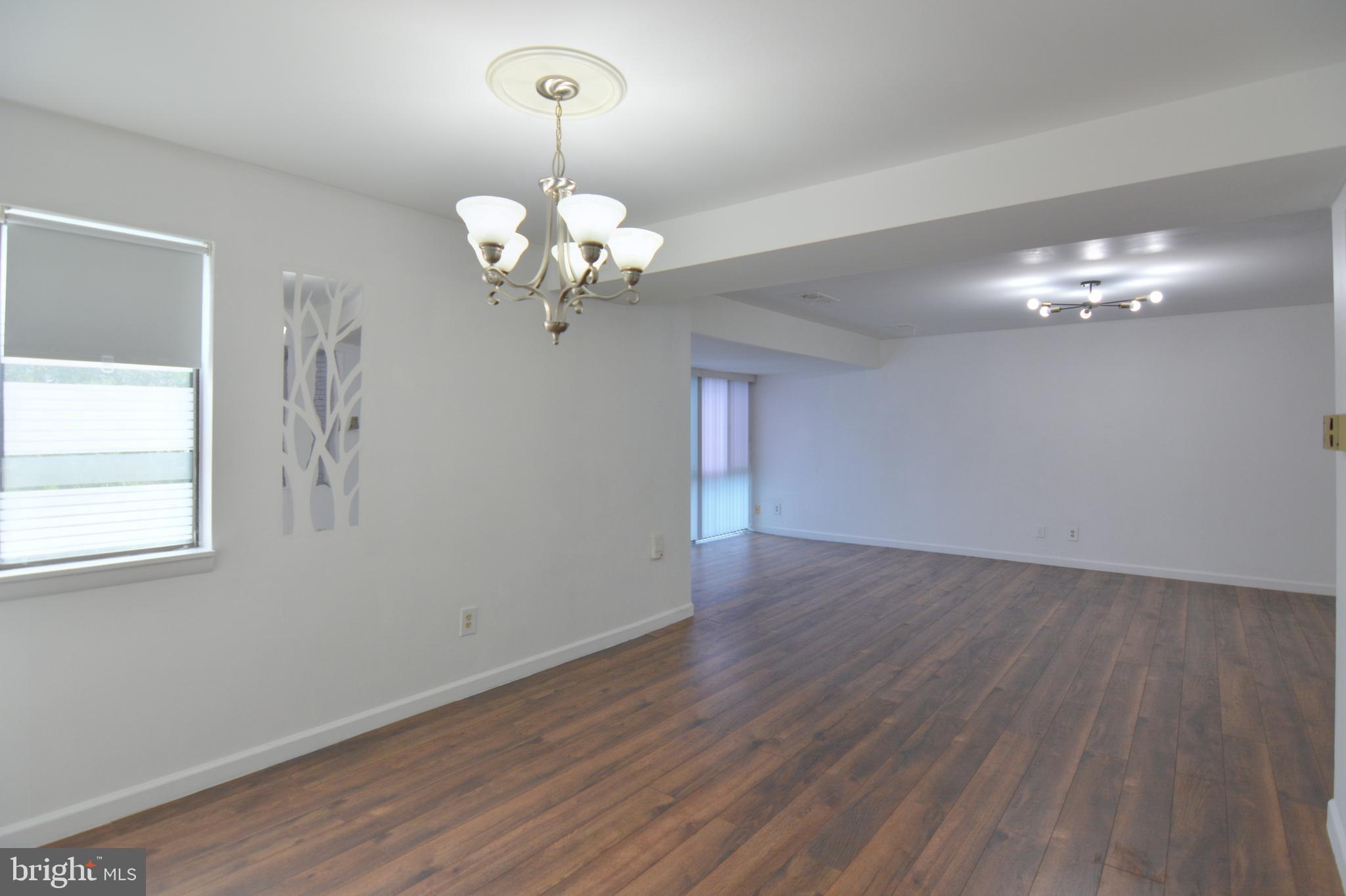 18905 Smoothstone Way, Unit I3 Gaithersburg, MD 20886 - Photo 13 of 32 a view of a chandelier in a room with wooden floor