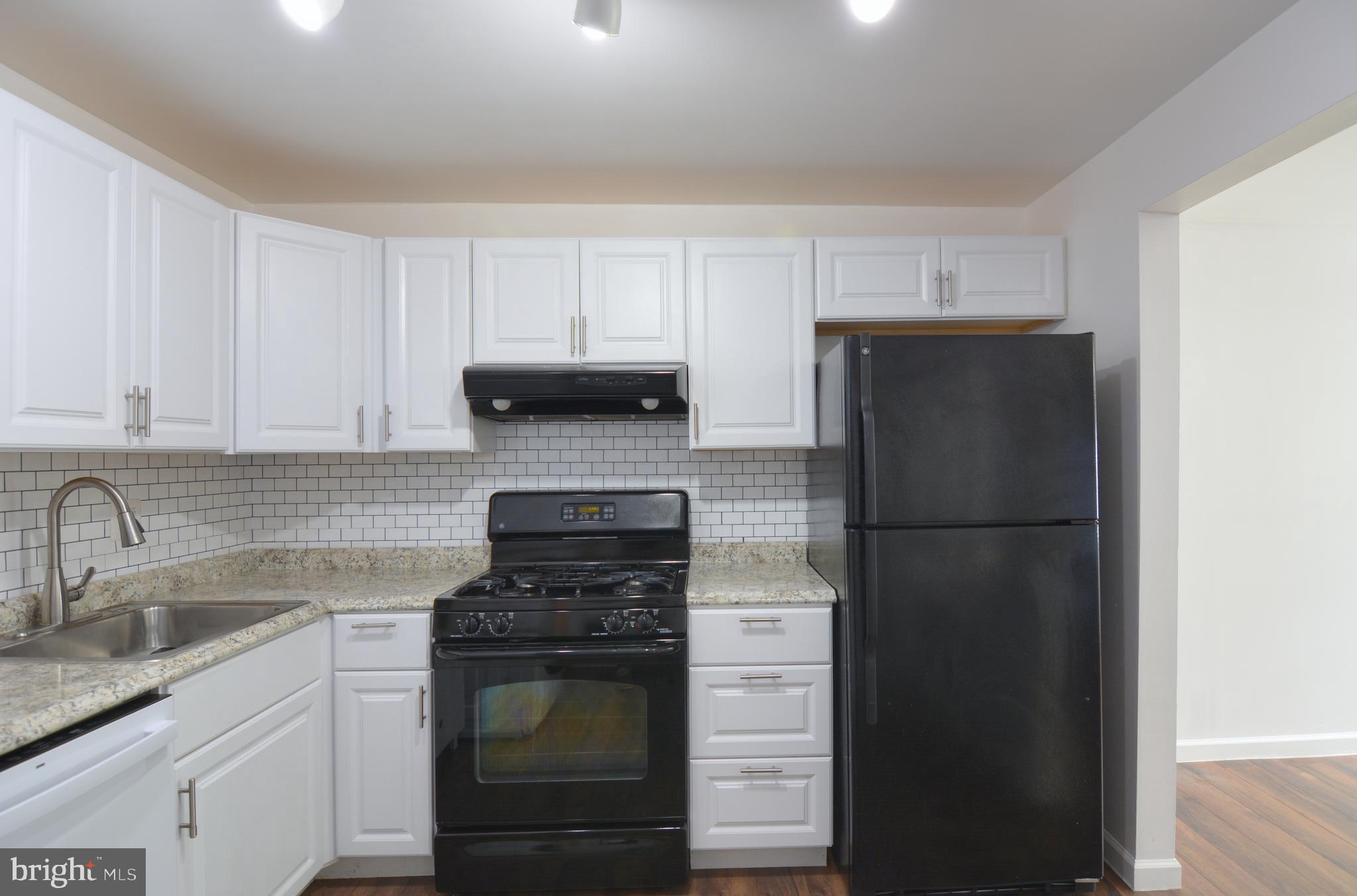 18905 Smoothstone Way, Unit I3 Gaithersburg, MD 20886 - Photo 16 of 32 a kitchen with a refrigerator sink and cabinets