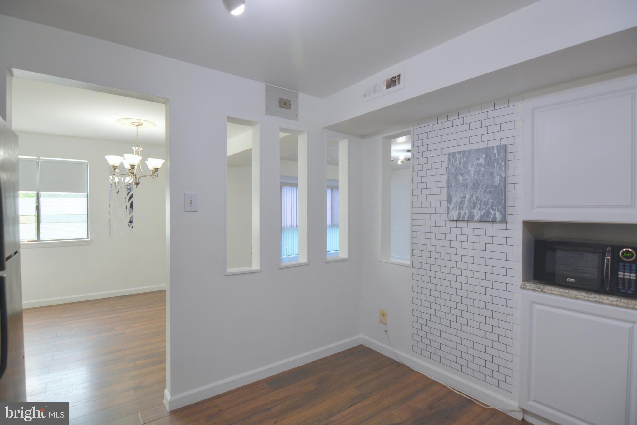 18905 Smoothstone Way, Unit I3 Gaithersburg, MD 20886 - Photo 18 of 32 a view of a hallway with wooden floor and a fireplace
