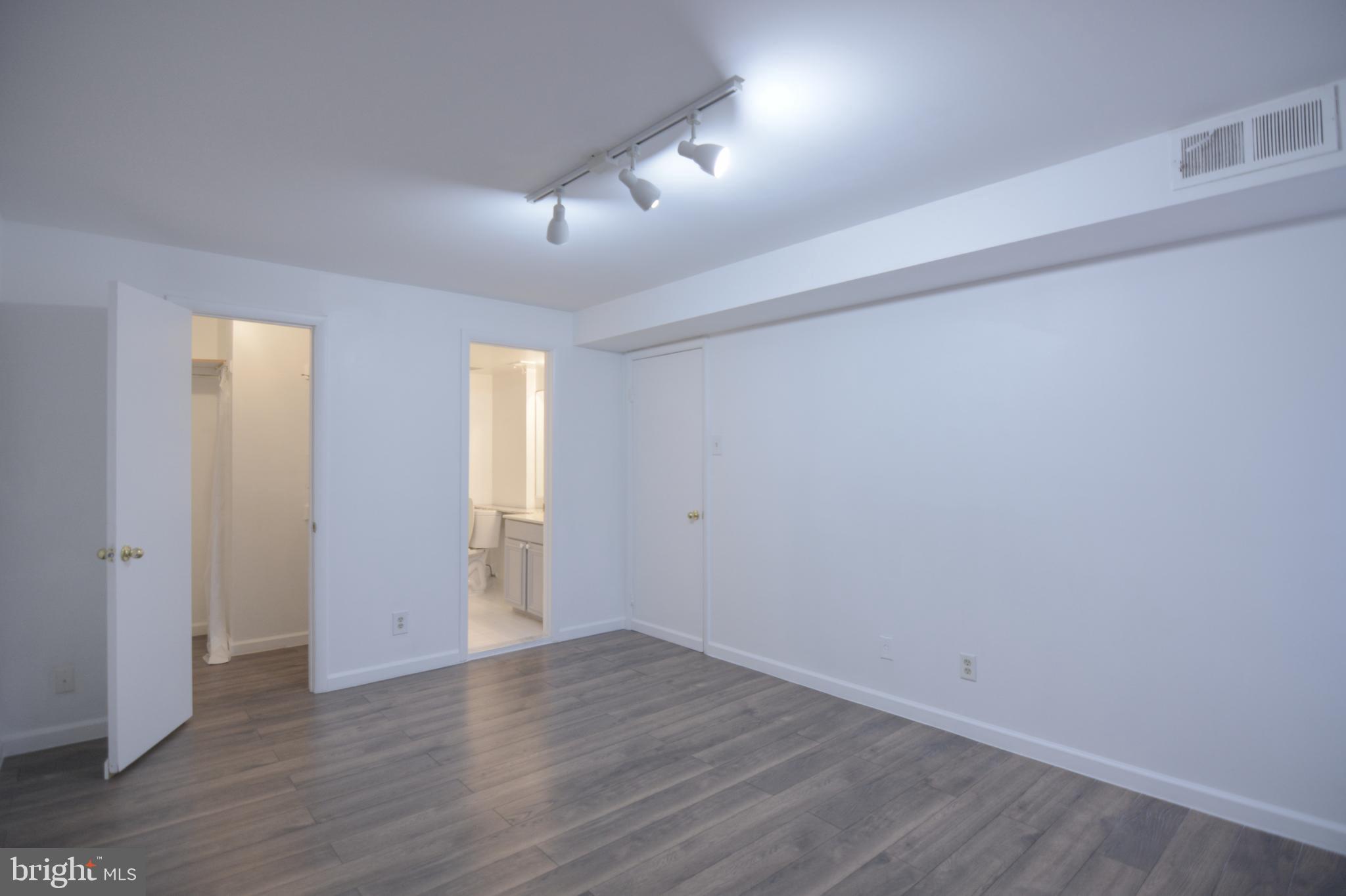 18905 Smoothstone Way, Unit I3 Gaithersburg, MD 20886 - Photo 26 of 32 an empty room with wooden floor and windows