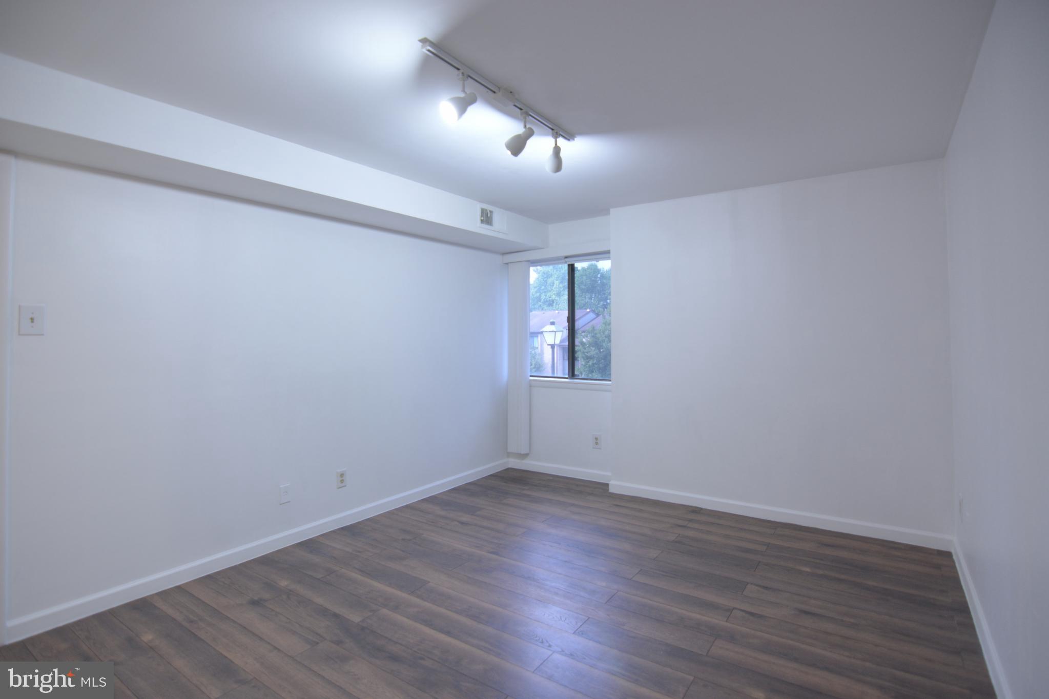 18905 Smoothstone Way, Unit I3 Gaithersburg, MD 20886 - Photo 27 of 32 wooden floor in an empty room with a window