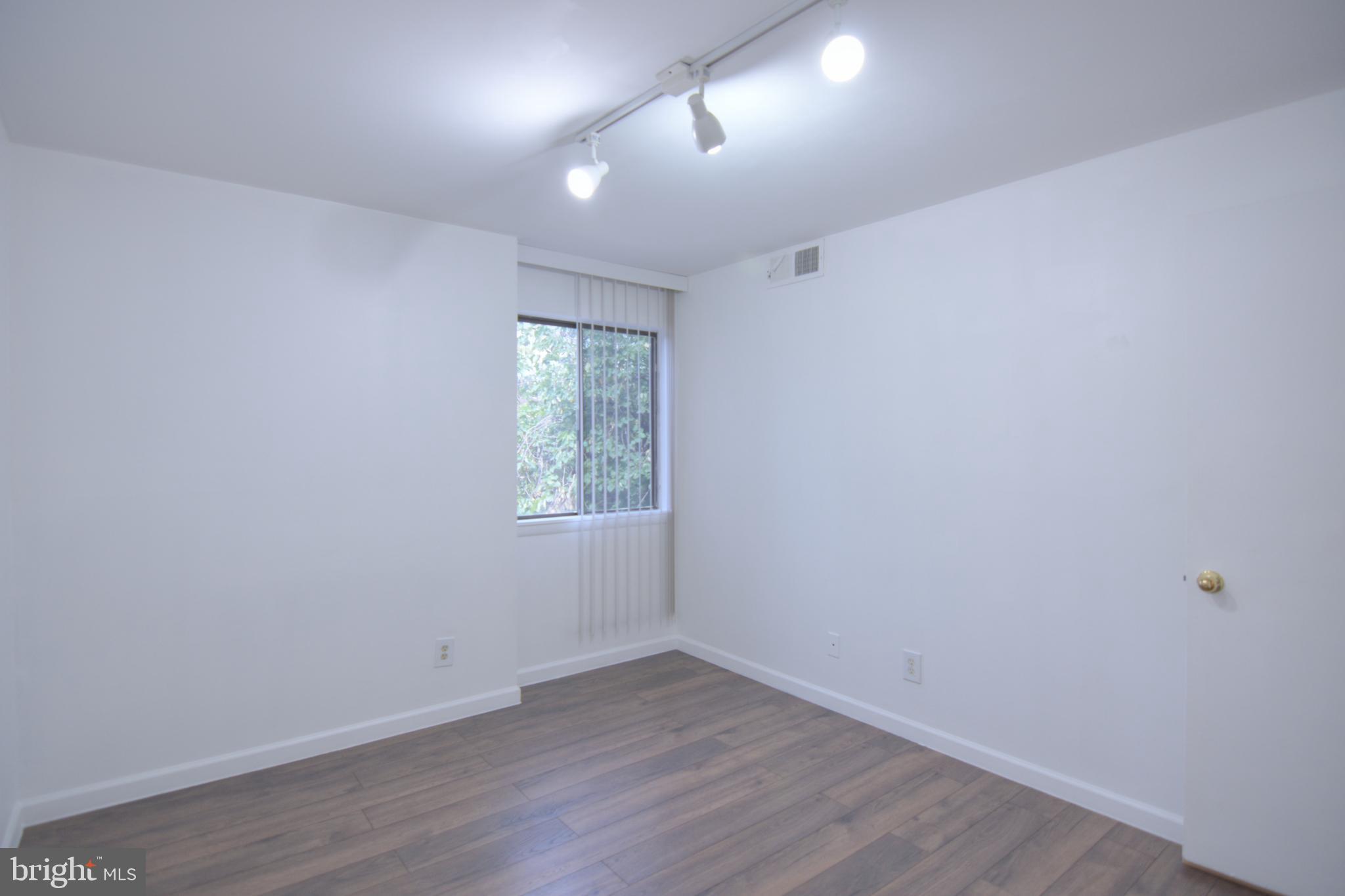 18905 Smoothstone Way, Unit I3 Gaithersburg, MD 20886 - Photo 32 of 32 an empty room with wooden floor and windows