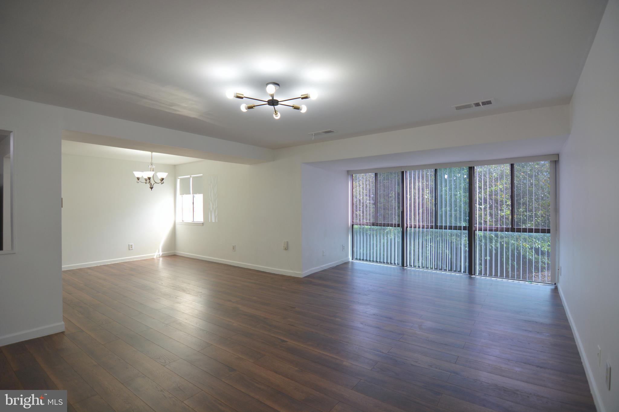 18905 Smoothstone Way, Unit I3 Gaithersburg, MD 20886 - Photo 6 of 32 a view of an empty room with wooden floor and a window