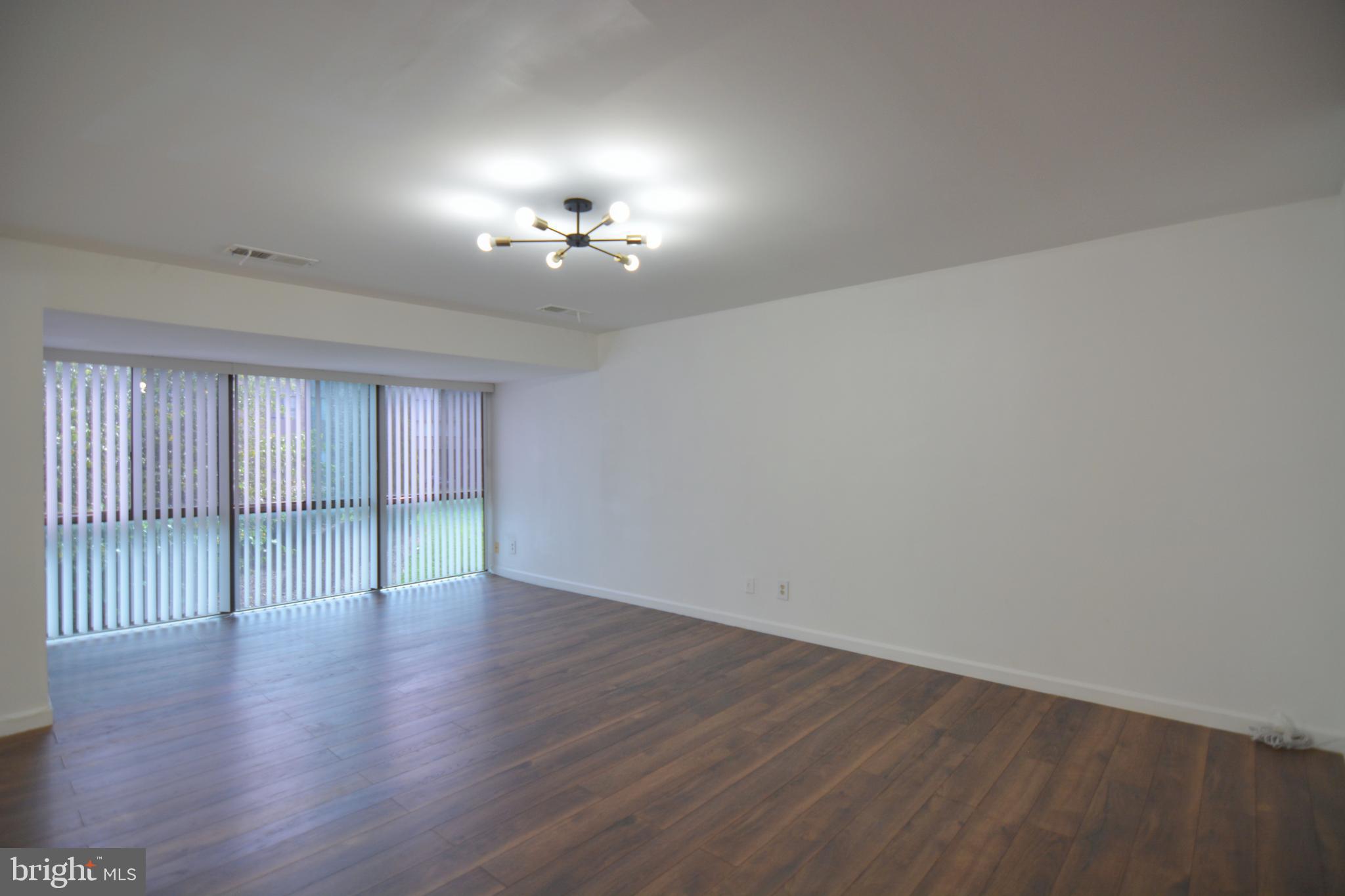 18905 Smoothstone Way, Unit I3 Gaithersburg, MD 20886 - Photo 7 of 32 a view of empty room with wooden floor and fan