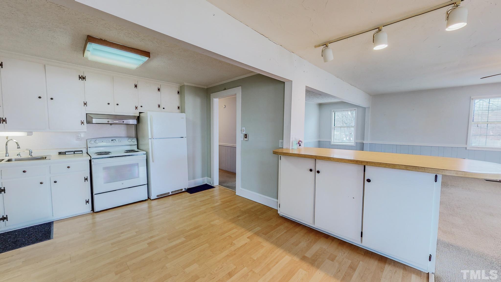 231 Patterson Drive Roxboro, NC 27573 - Photo 3 of 41 a kitchen with white cabinets and wooden floors