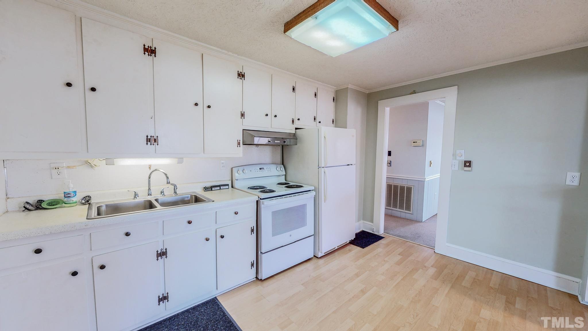 231 Patterson Drive Roxboro, NC 27573 - Photo 10 of 41 a kitchen with granite countertop white cabinets and white appliances