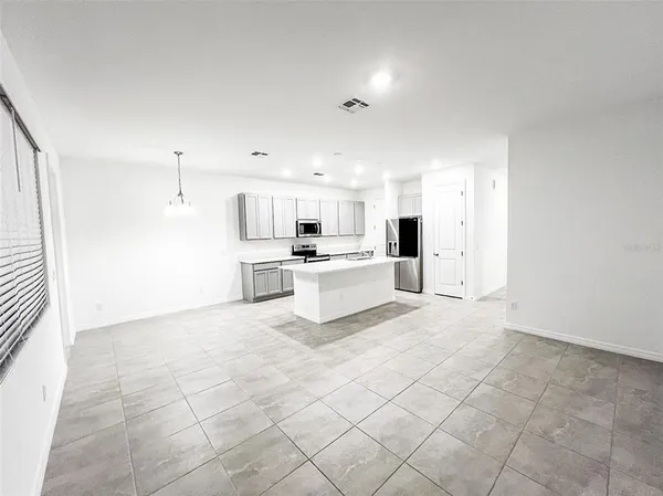 a large white kitchen with white cabinets and stainless steel appliances
