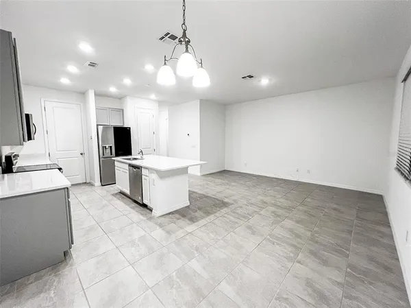 a large white kitchen with a large counter top appliances and cabinets