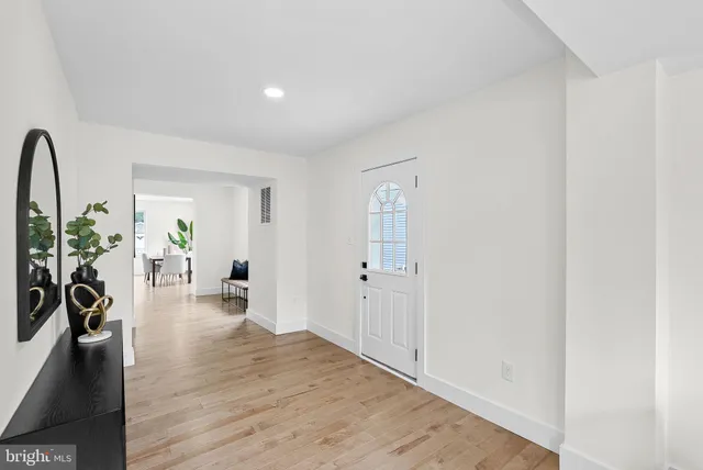 a kitchen with stainless steel appliances kitchen island wooden floors and white cabinets