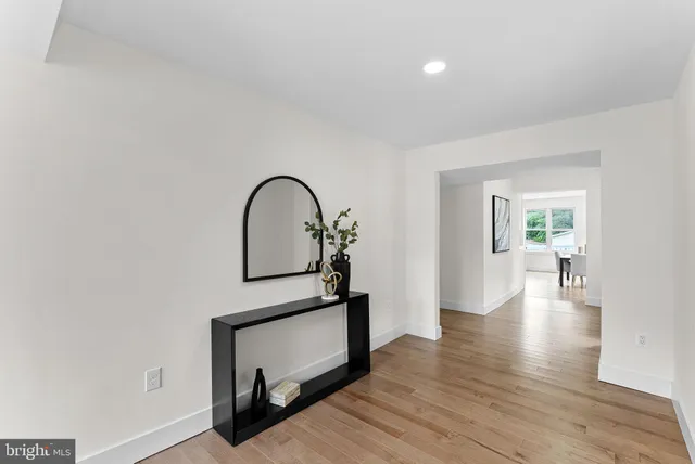 a large white kitchen with window and stainless steel appliances