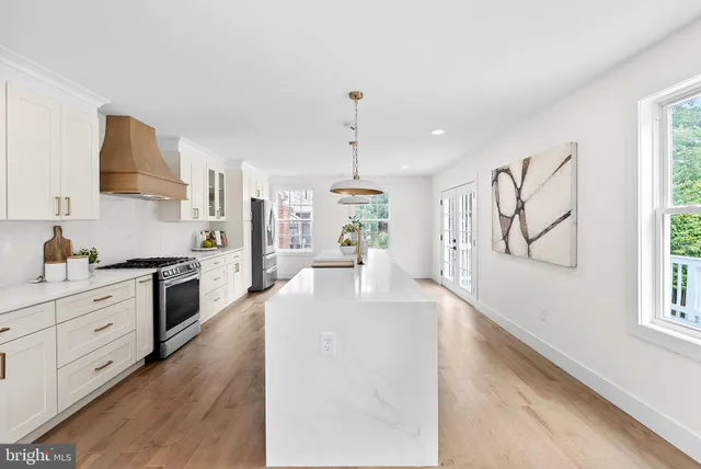 a large white kitchen with wooden floors