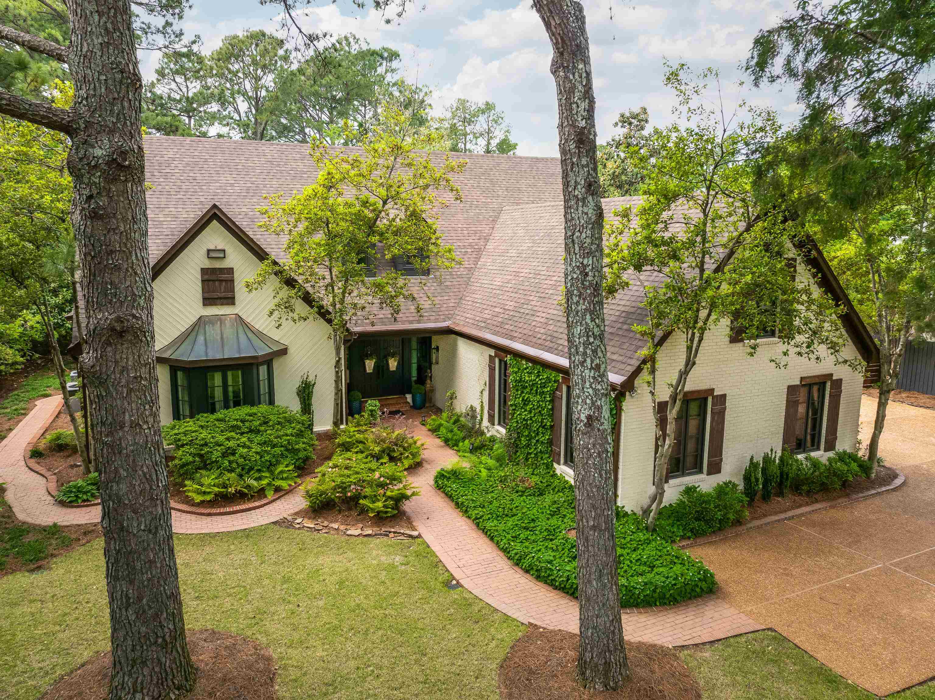 Traditional style residence featuring a light-colored exterior, dark trim, and a shingle roof