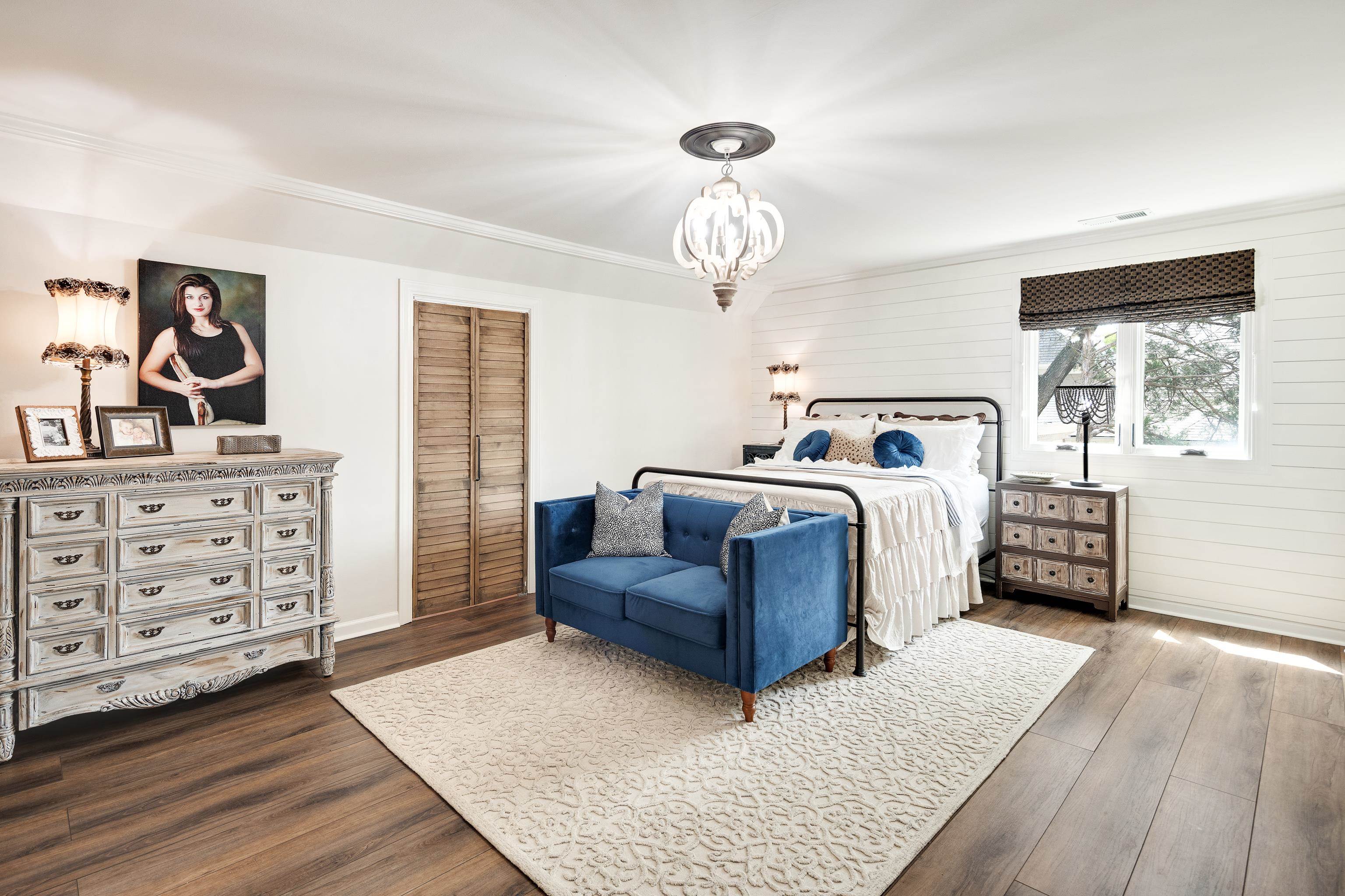 811 Sweetbrier Road Memphis, TN 38120 - Photo 23 of 40 Spacious room featuring wood-finish flooring, white shiplap accent wall, and a decorative ceiling fixture