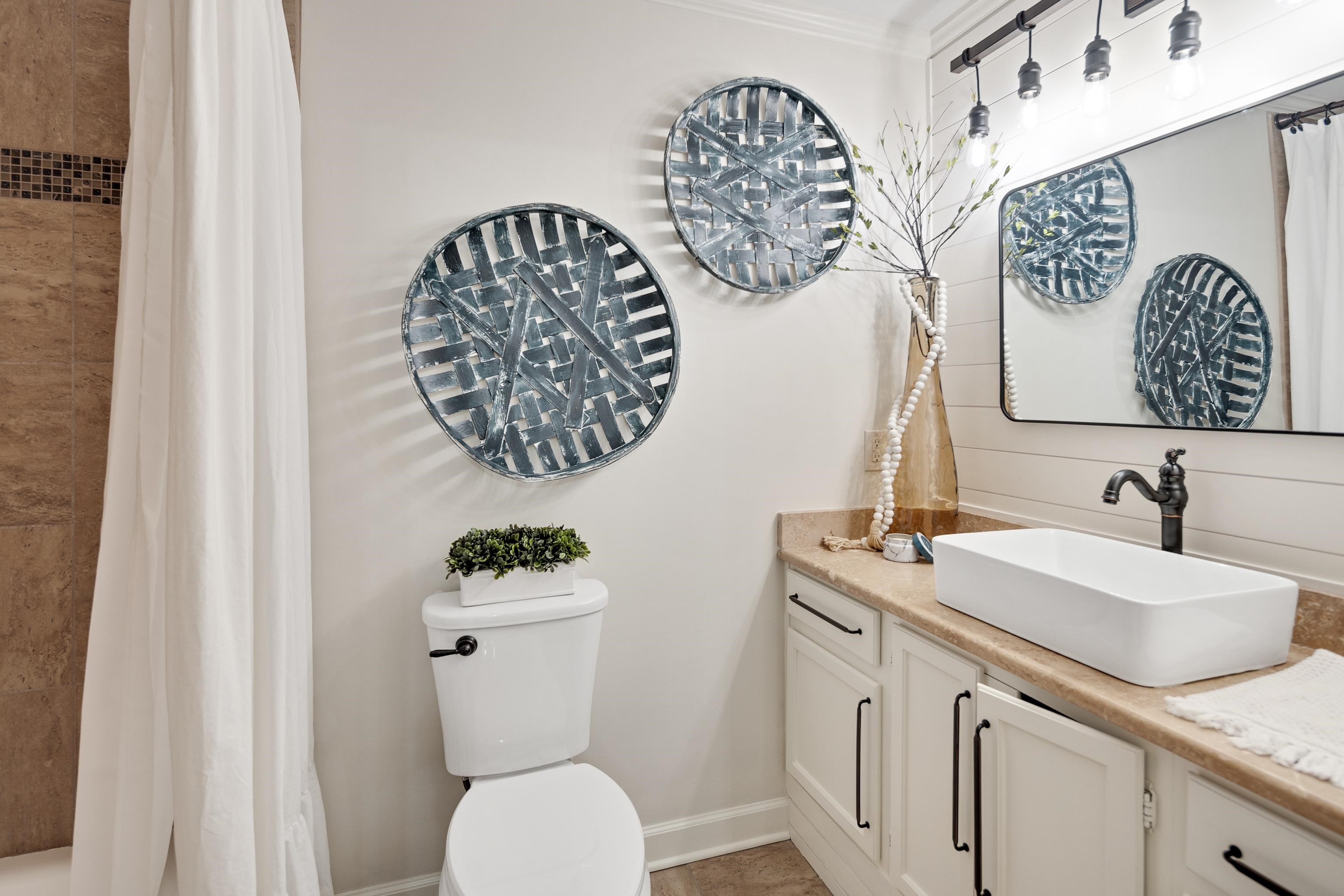 811 Sweetbrier Road Memphis, TN 38120 - Photo 24 of 40 Bathroom featuring a white rectangular vessel sink, dark bronze faucet, light-colored countertop, and white cabinetry with dark bronze hardware