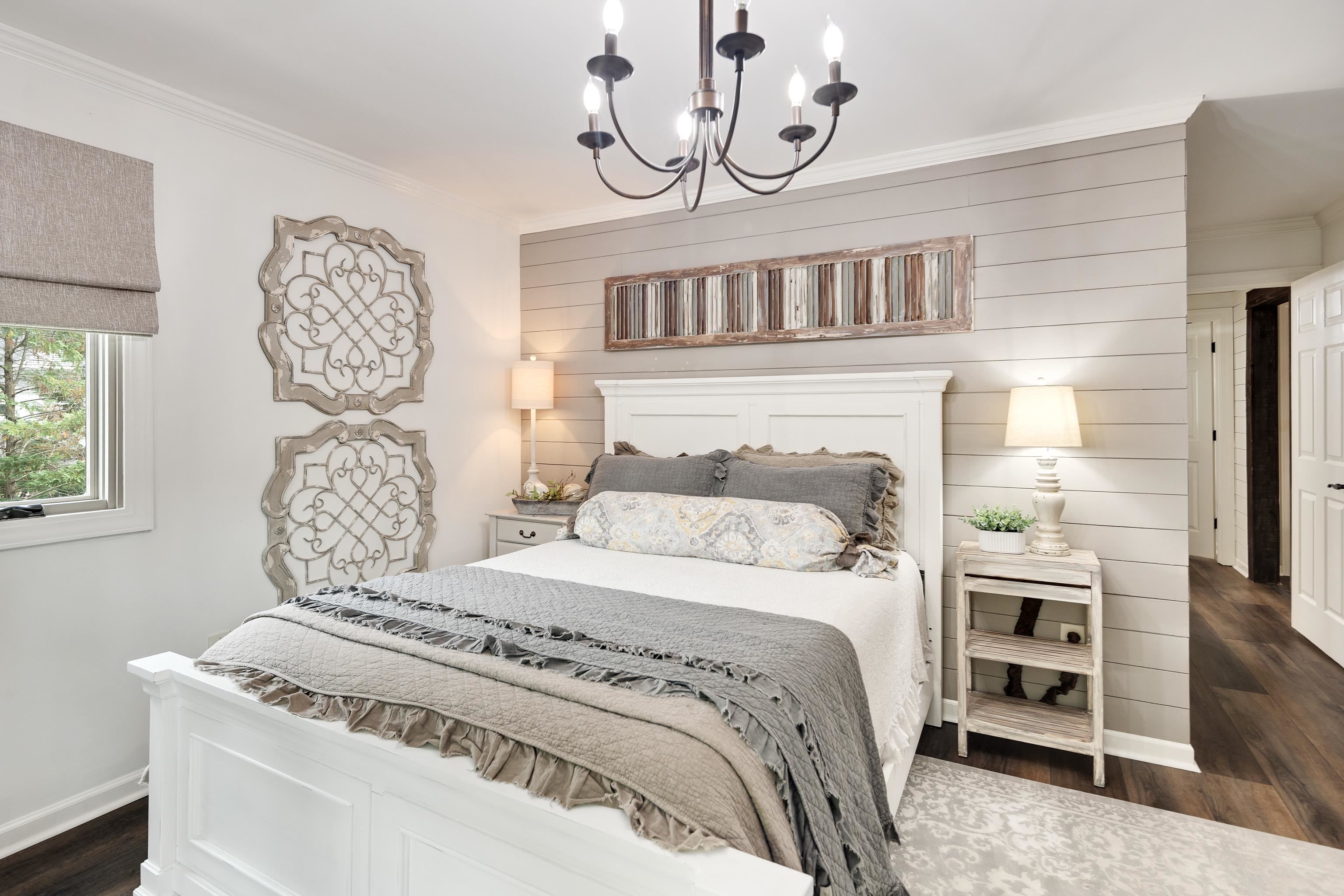 811 Sweetbrier Road Memphis, TN 38120 - Photo 26 of 40 Bedroom featuring a shiplap accent wall, dark wood-finish flooring, and a multi-arm chandelier