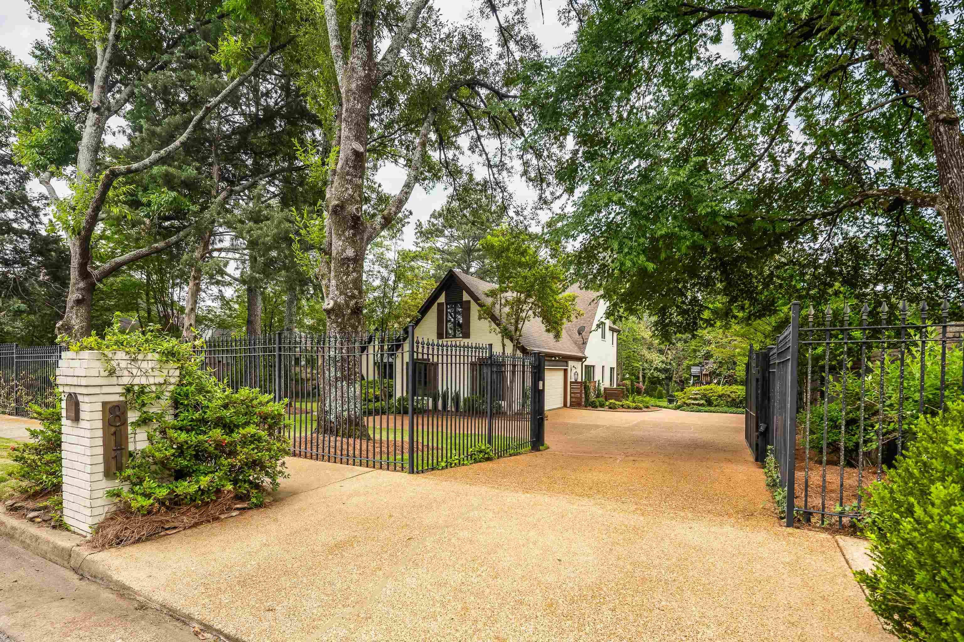 811 Sweetbrier Road Memphis, TN 38120 - Photo 3 of 40 Gated property entrance featuring a brick pillar with house numbers and mature trees