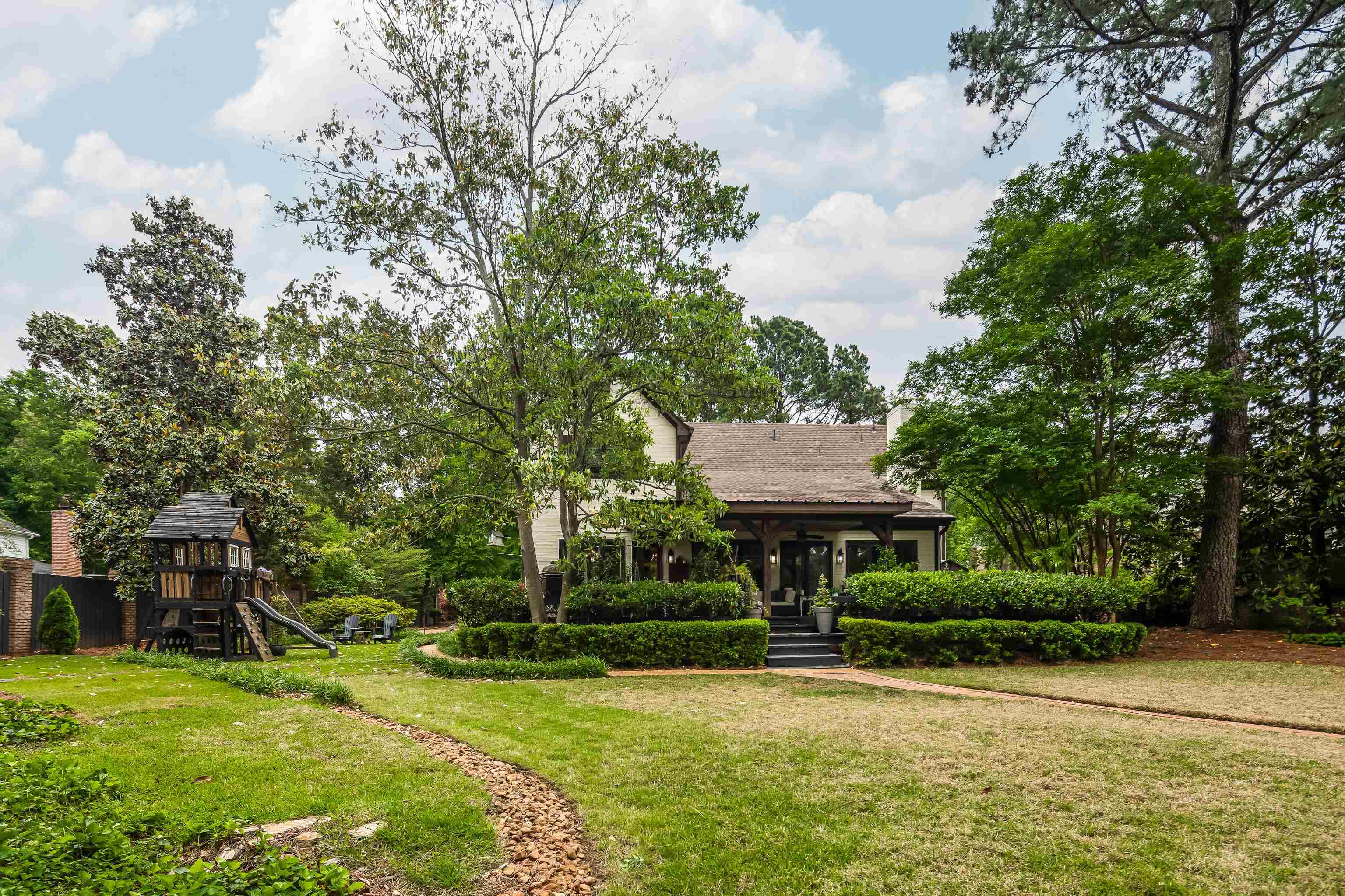 811 Sweetbrier Road Memphis, TN 38120 - Photo 35 of 40 Spacious rear yard with natural grass, mature trees, and a stone-lined garden path