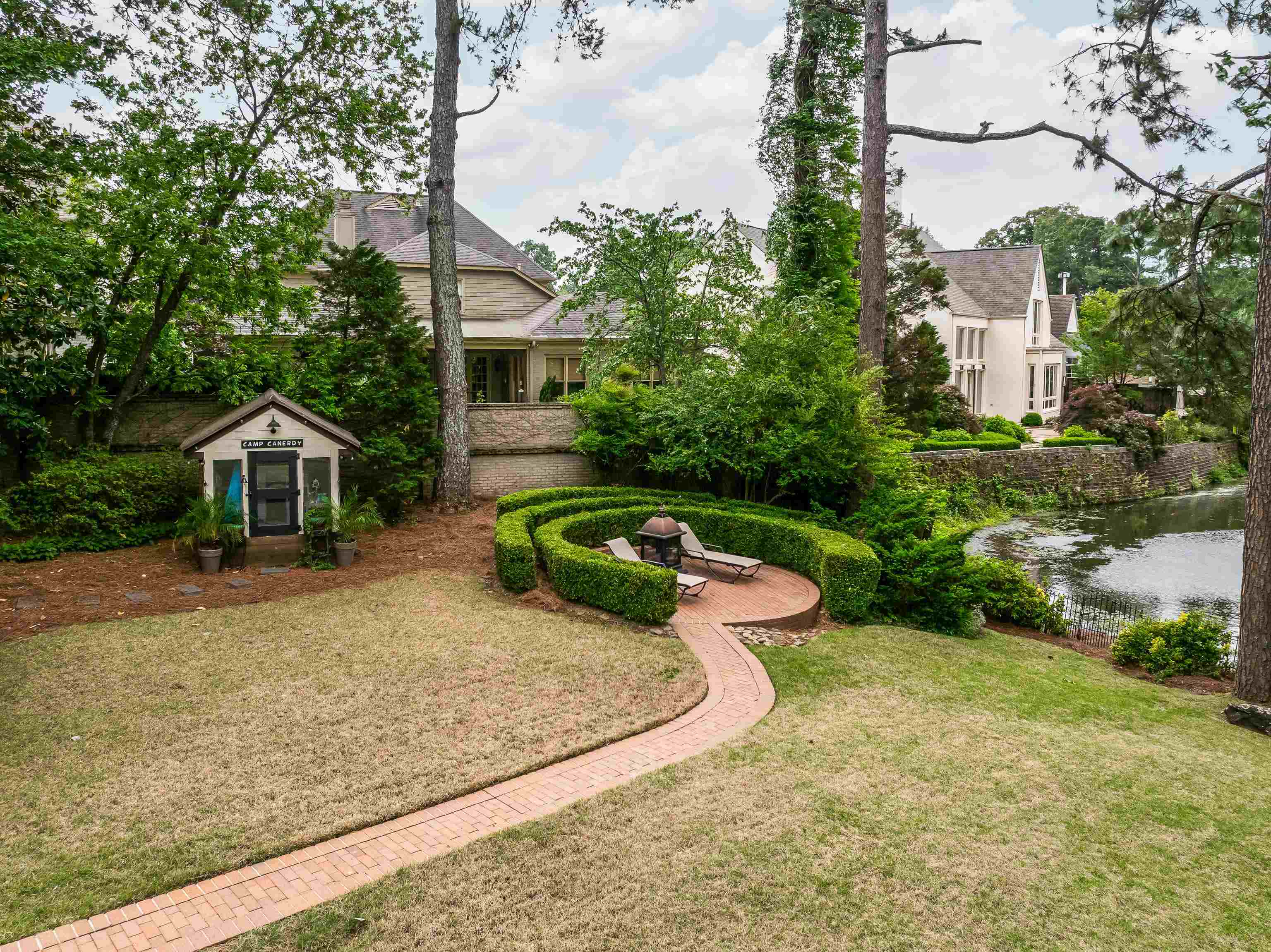 811 Sweetbrier Road Memphis, TN 38120 - Photo 37 of 40 Expansive rear yard featuring a brick pathway leading to a circular patio with sculpted hedges