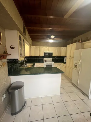 a view of a kitchen with stainless steel appliances granite countertop a sink and a stove