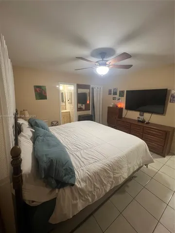a spacious bedroom with a bed and a flat screen tv