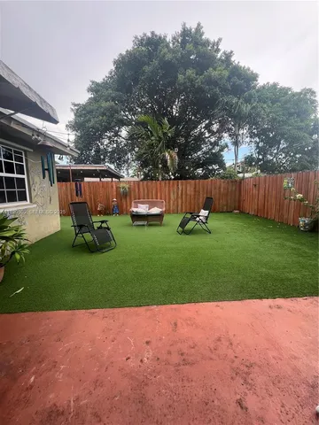 a view of a backyard with table and chairs and wooden fence