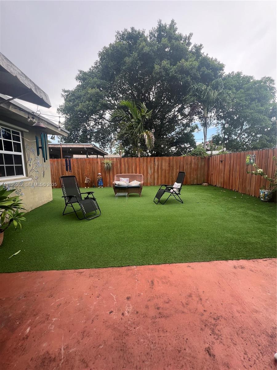 2815 Southwest 36th Avenue Miami, FL 33133 - Photo 23 of 25 a view of a backyard with table and chairs and wooden fence