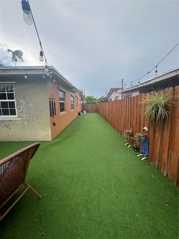 a view of a backyard with potted plants and floor to ceiling window