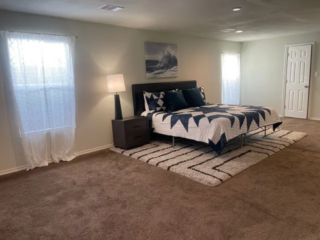 a spacious bedroom with a bed and window