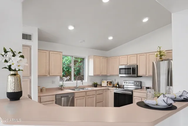 a kitchen with kitchen island granite countertop a sink cabinets and stainless steel appliances