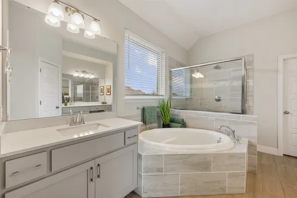 a spacious bathroom with a granite countertop tub sink and mirror