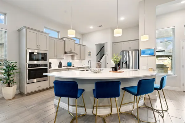 a kitchen with stainless steel appliances kitchen island granite countertop a sink and a refrigerator