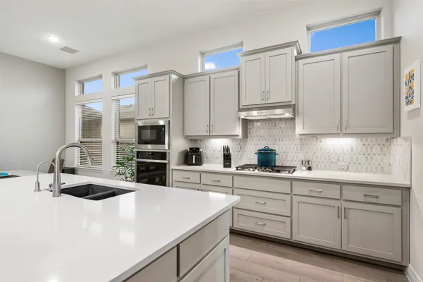 a kitchen with stainless steel appliances granite countertop a sink a stove and a refrigerator