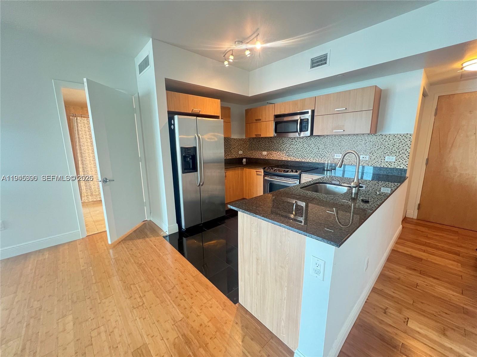 350 South Miami Avenue, Unit 1905 Miami, FL 33130 - Photo 3 of 26 a kitchen with stainless steel appliances granite countertop a sink and a refrigerator