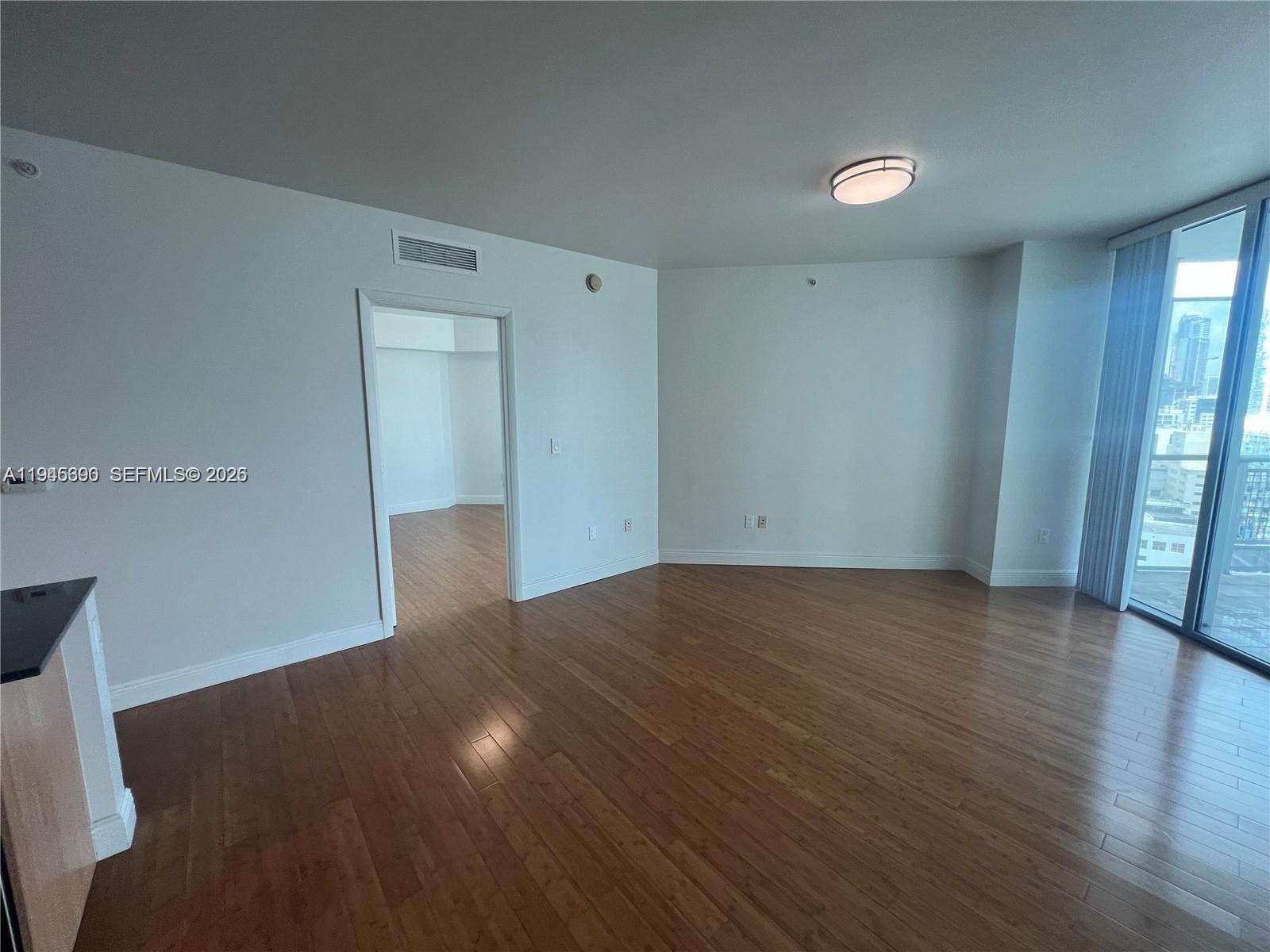350 South Miami Avenue, Unit 1905 Miami, FL 33130 - Photo 5 of 26 a view of an empty room with glass door and wooden floor