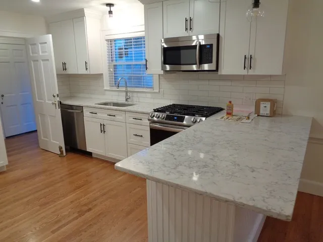 a kitchen with stainless steel appliances granite countertop a sink stove and microwave