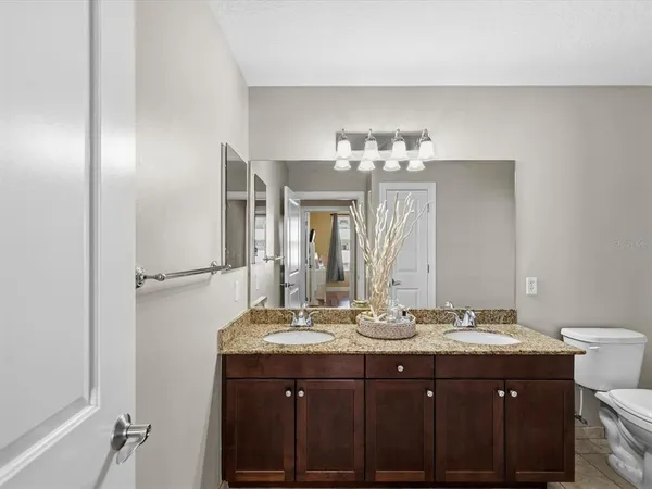 a bathroom with a granite countertop sink toilet a mirror and shower