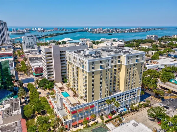 a view of a patio with table and chairs potted plants and a large tree