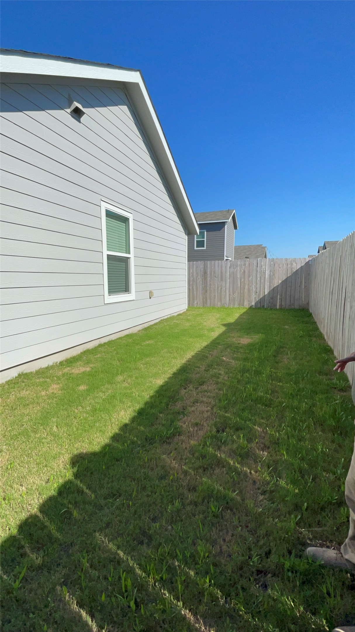 212 Marty Allen Loop Jarrell, TX 76537 - Photo 11 of 13 Side yard featuring a manicured lawn, gray horizontal siding, and a white-framed window